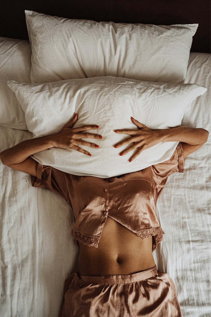 Woman resting in bed with soft linen pillows