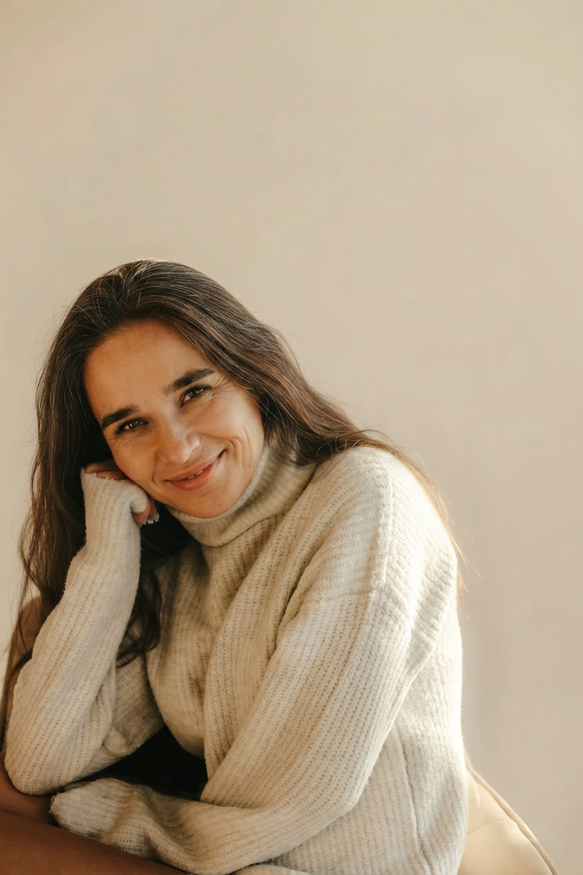 Laurie smiling in a cream turtleneck sweater